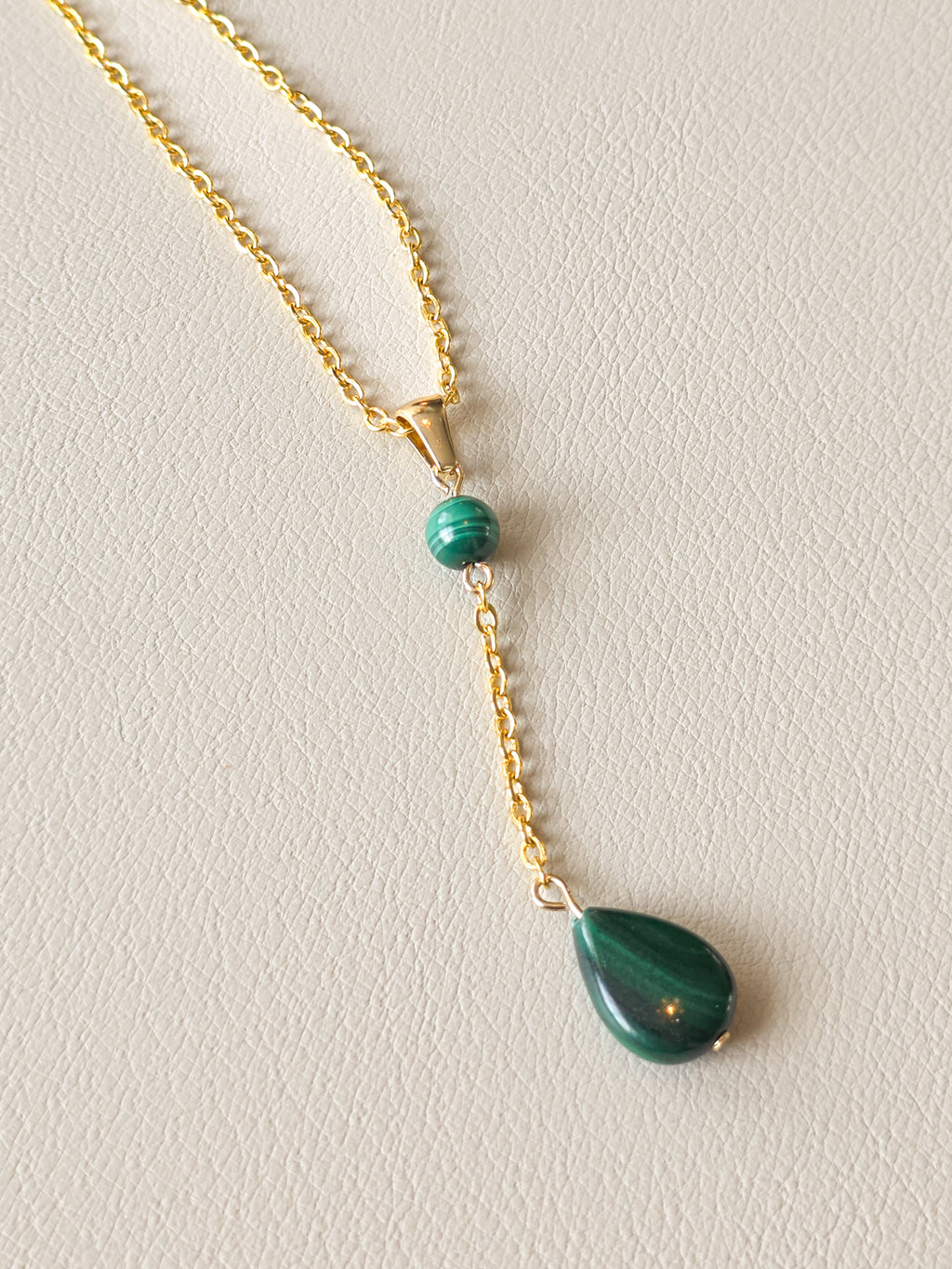 Gold PVD stainless steel necklace with a malachite teardrop pendant, round malachite bead, magnetic clasp, and extender chain.