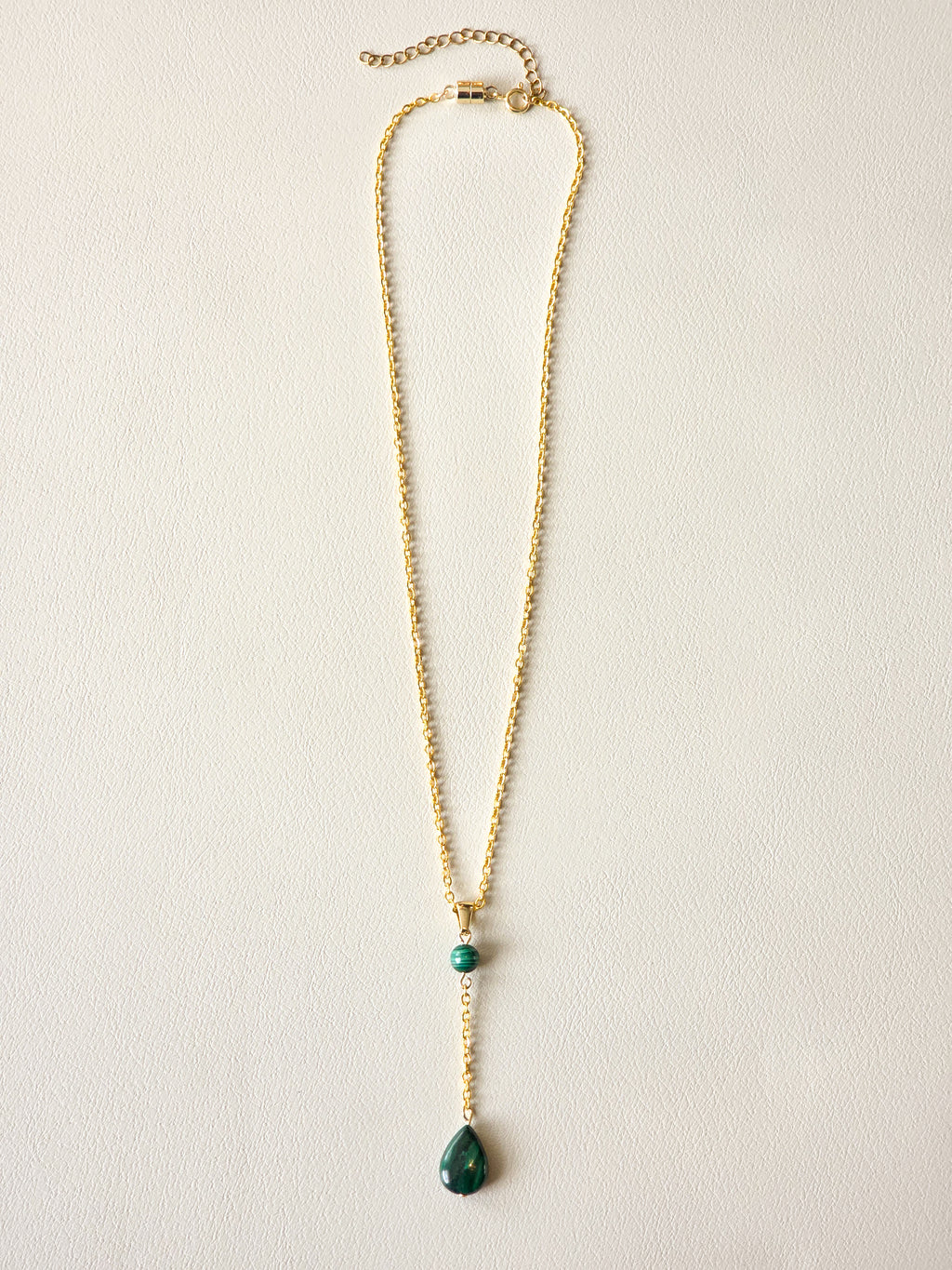 Malachite drop pendant necklace with gold PVD stainless steel chain and polished green stone details.