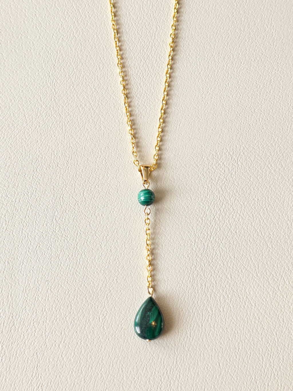 Malachite drop pendant necklace with gold PVD stainless steel chain and polished green stone details.