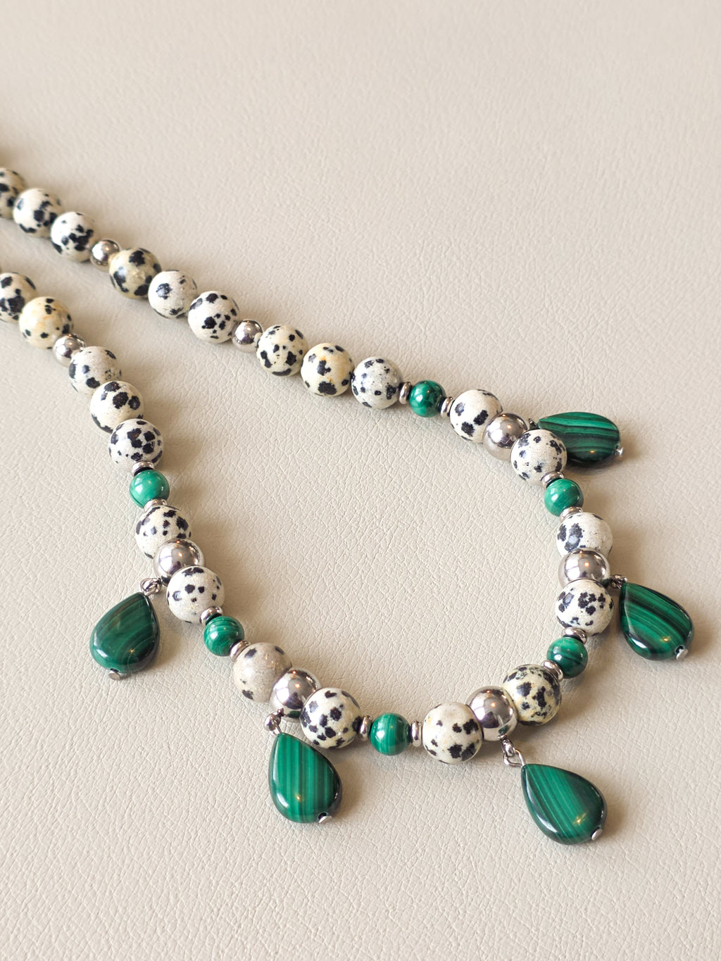 Side view of malachite and dalmatian jasper beaded necklace