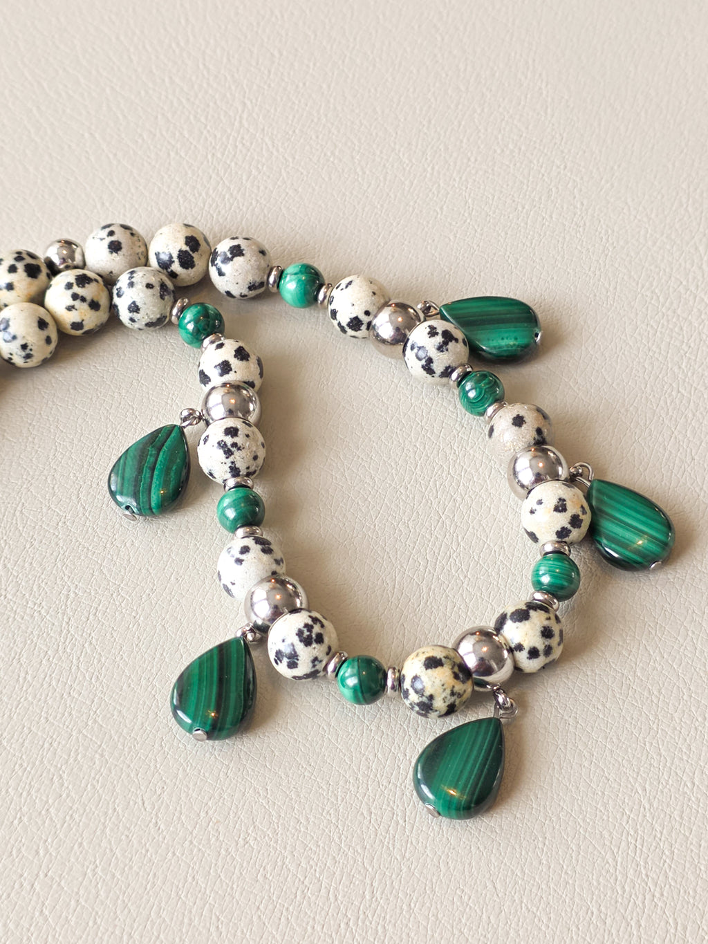 close up view of malachite and dalmatian jasper beaded necklace