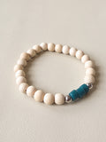 Beaded bracelet with a blue and silver accent on a light gray background